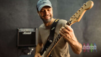 Главный герой (парень) на съемку мастер-класса игры на электрогитаре, ударных